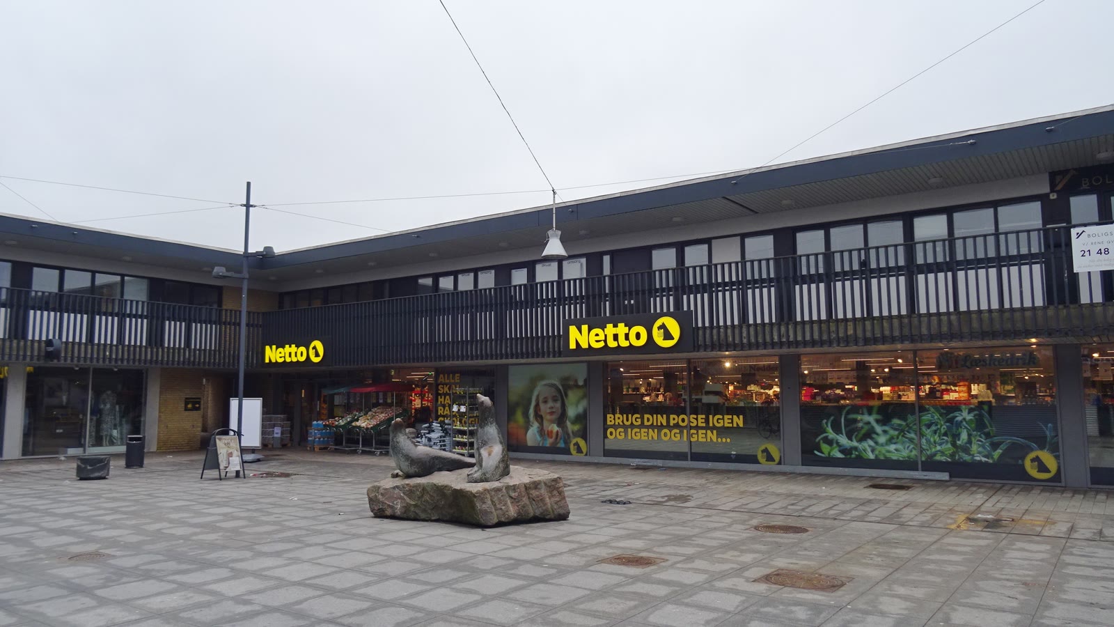 Søløvetorvet i Egedal Centret i Stenløse med Netto og en skulptur på torvet.