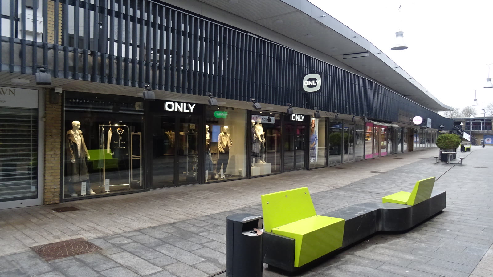 Butiksfacader i Egedal Centret med tøjbutikken ONLY og limegrønne bænke i gågaden.